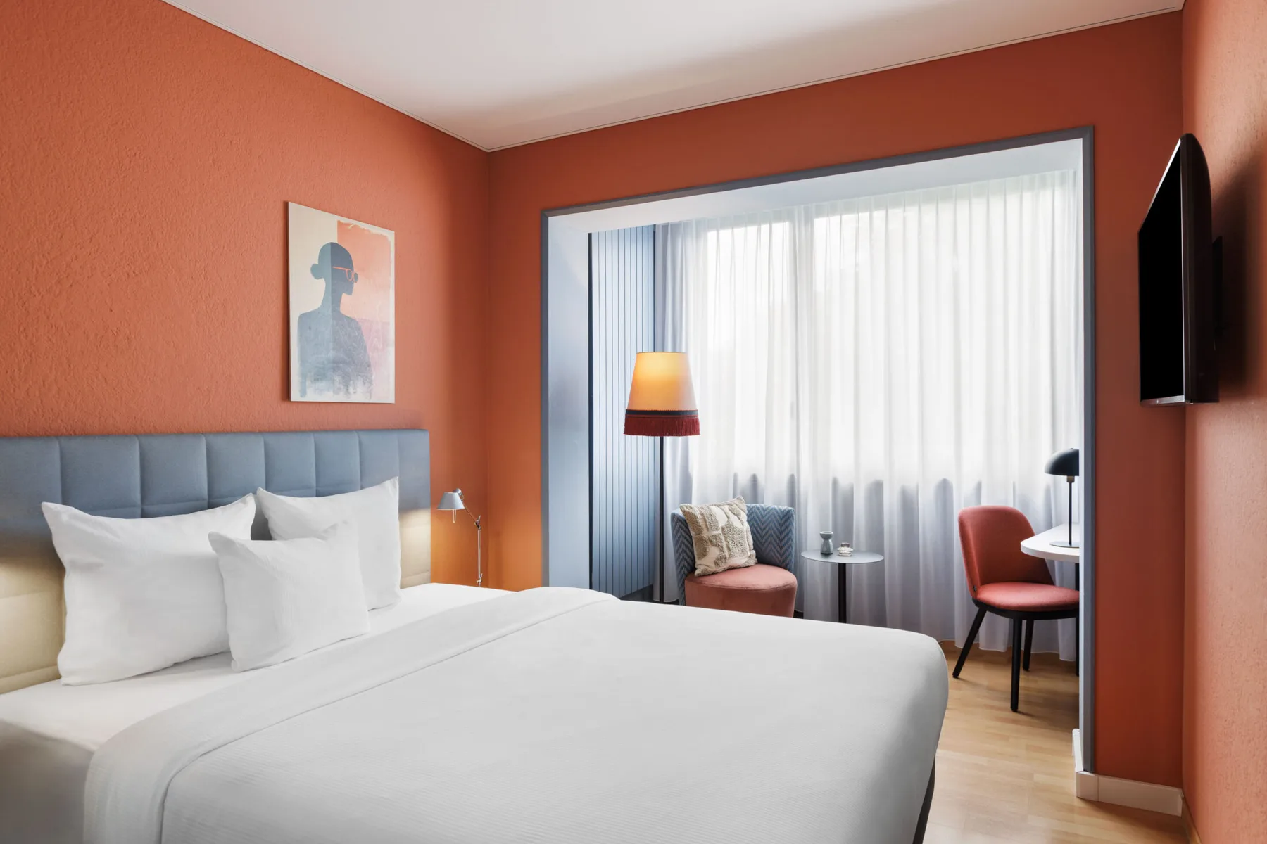 Business room with a double bed, seating area and desk.