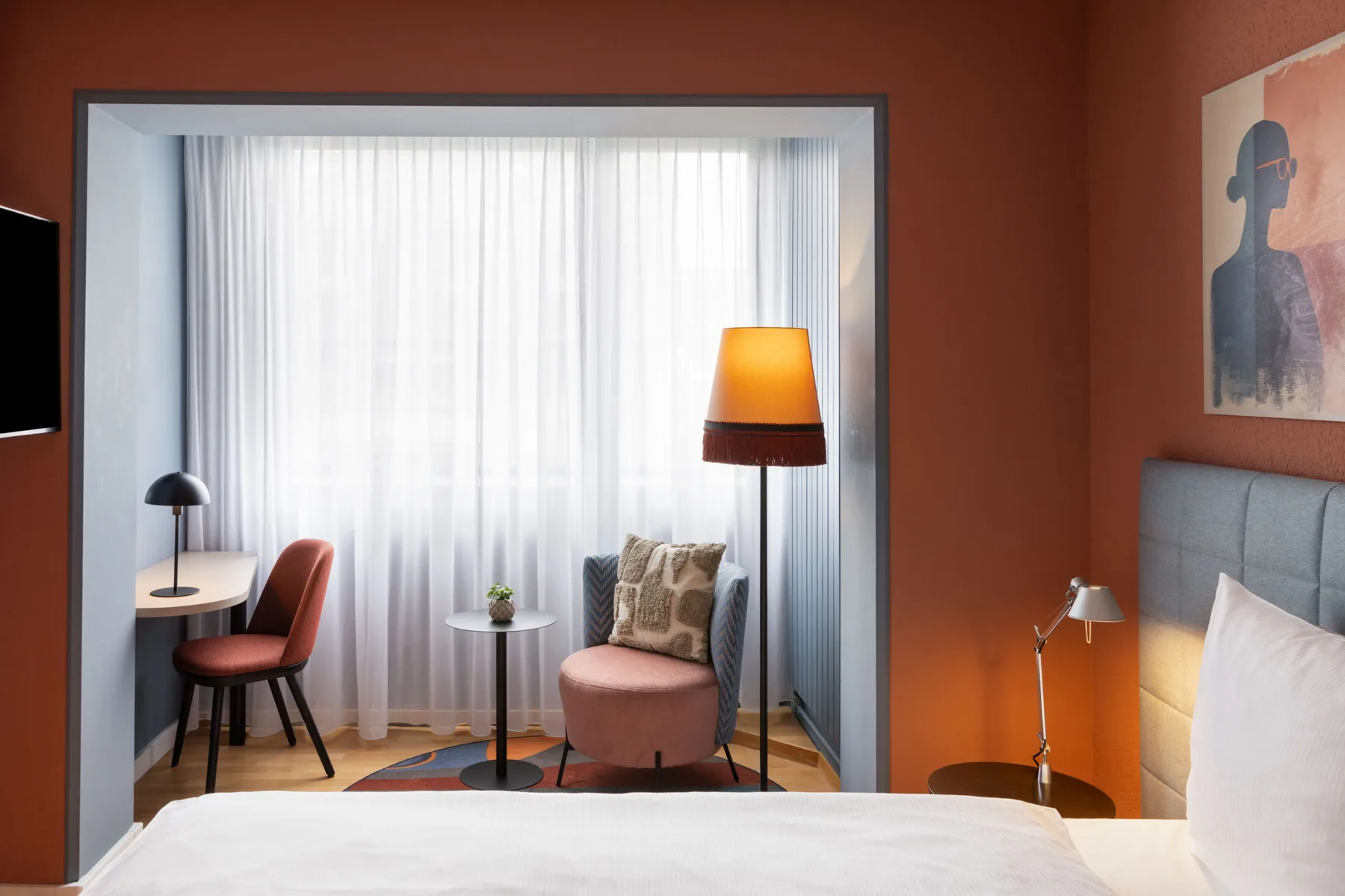Comfort room with a bed and window-side seating area.