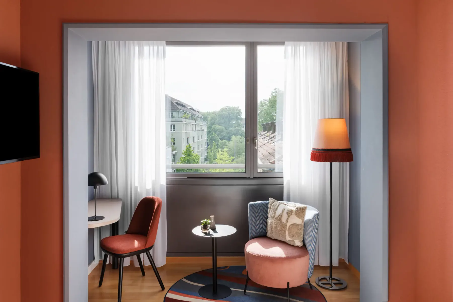 Window-side seating and desk in a comfort room.