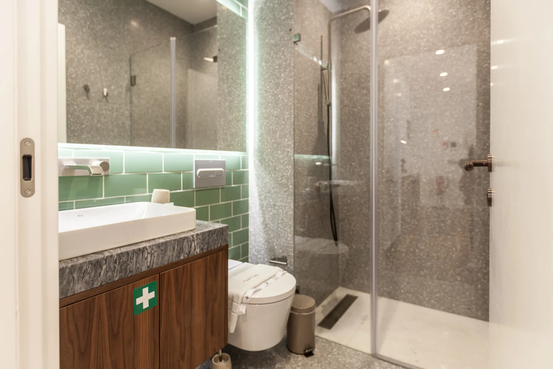 A bathroom with a sink, toilet, and glass-enclosed shower.