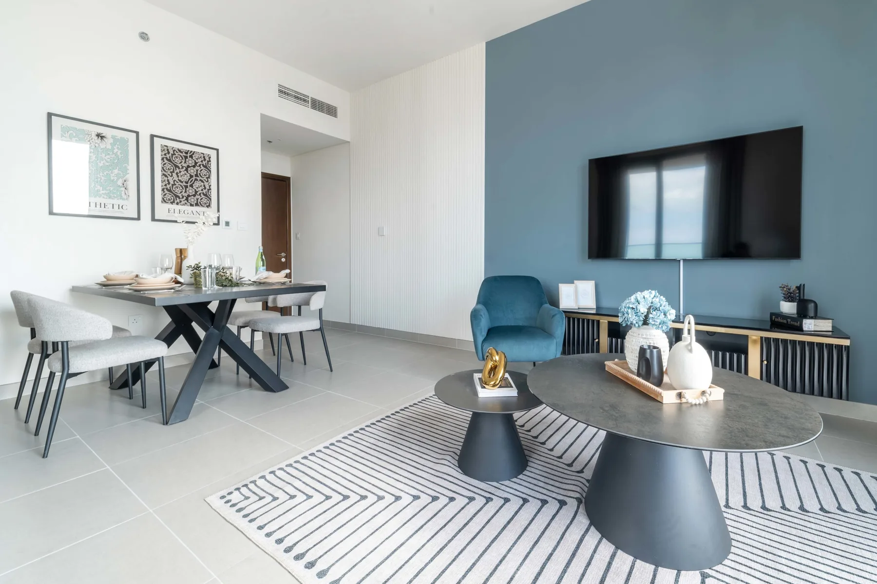 Una sala de estar y comedor moderna con televisión, asientos y una mesa de comedor.