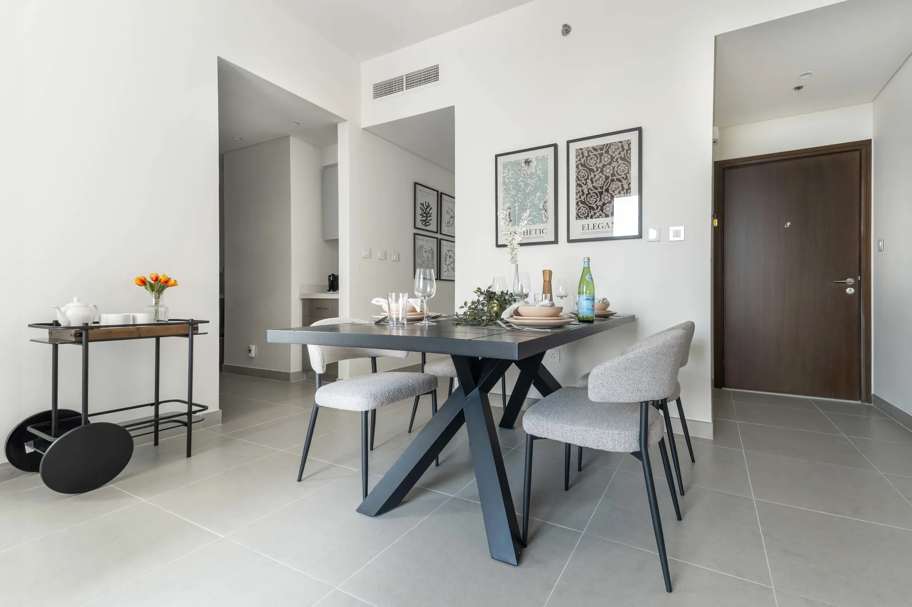 Comedor con una mesa y sillas bajo cuadros enmarcados.