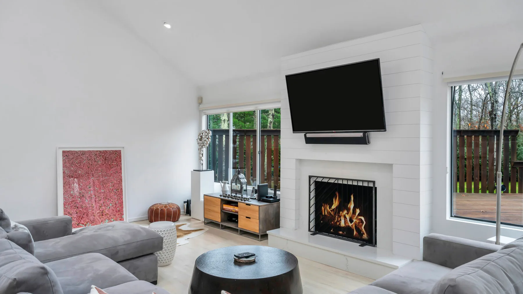 Una sala luminosa con asientos, un televisor y una chimenea.