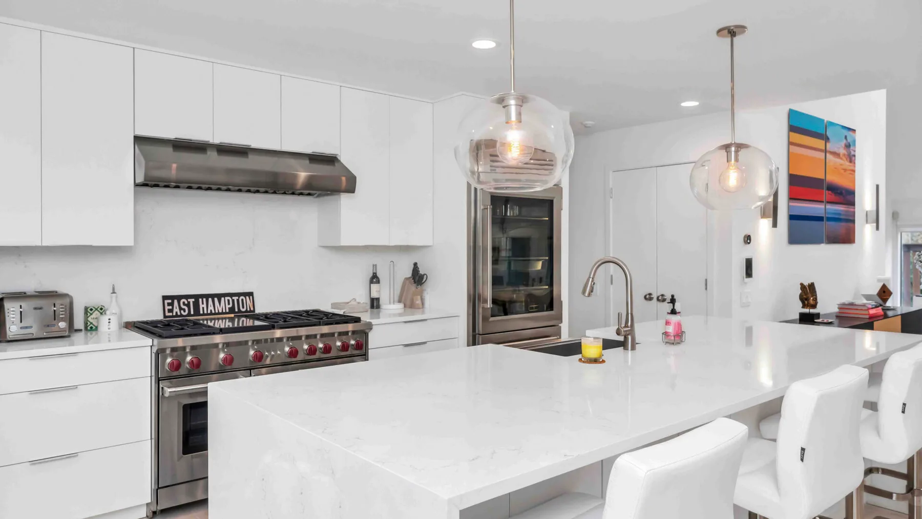 Una cocina moderna y luminosa con una isla grande y electrodomésticos de acero inoxidable.