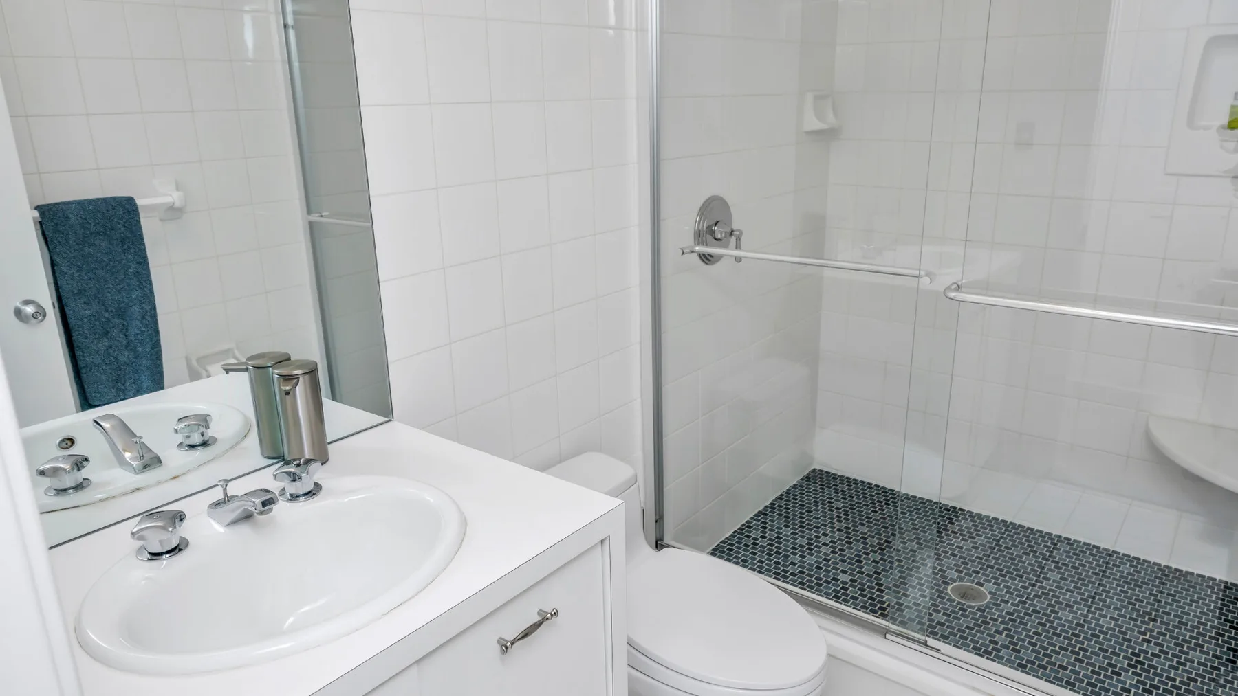 Un baño alicatado con lavabo y ducha a ras de suelo.