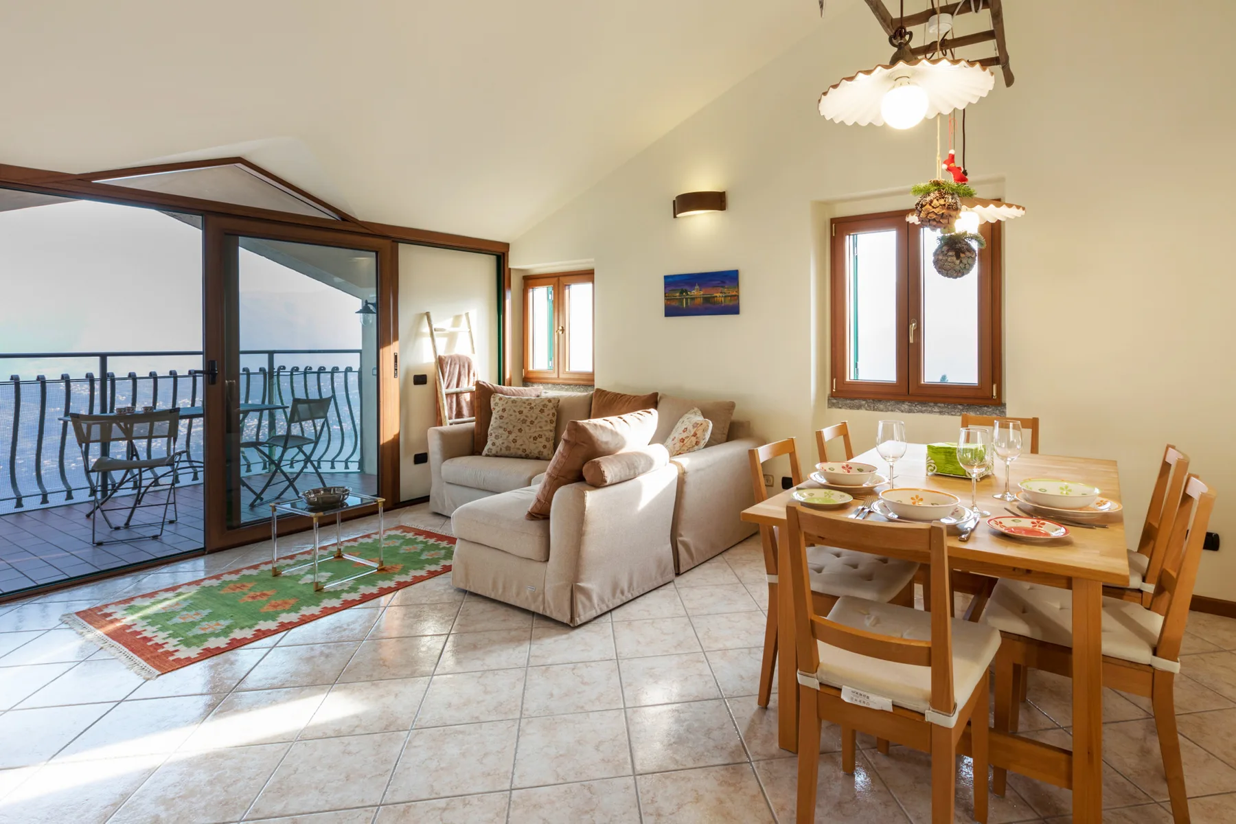 A bright living and dining area opens onto a balcony through sliding glass doors.
