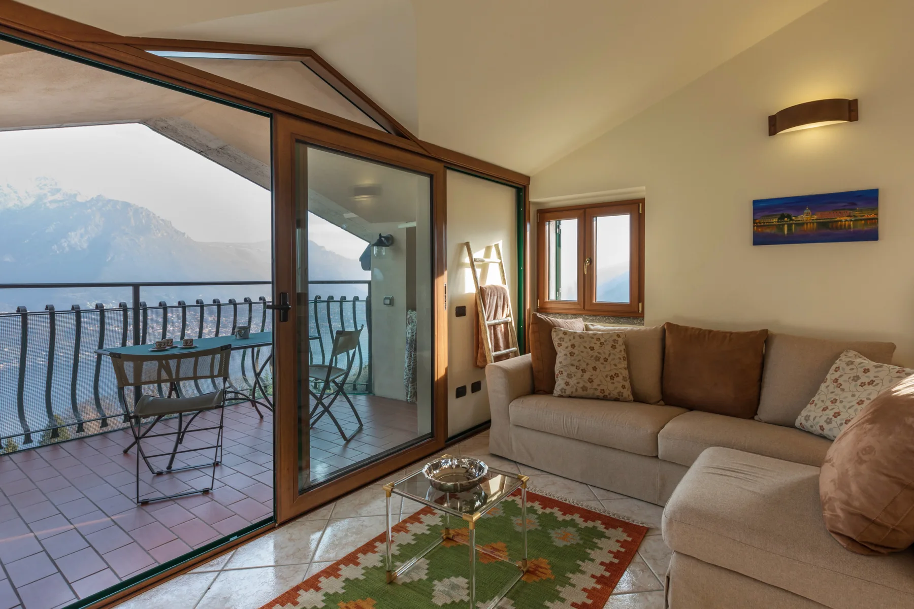 A living room with seating beside glass doors opening onto a balcony.