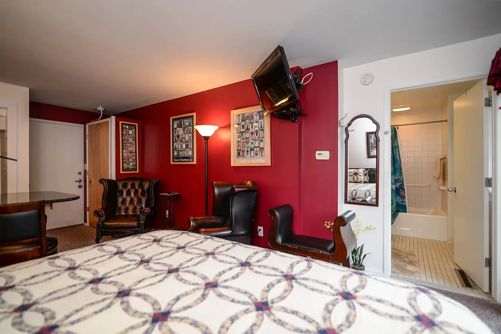 Habitación Charleston con paredes rojas, zona de estar y televisor.