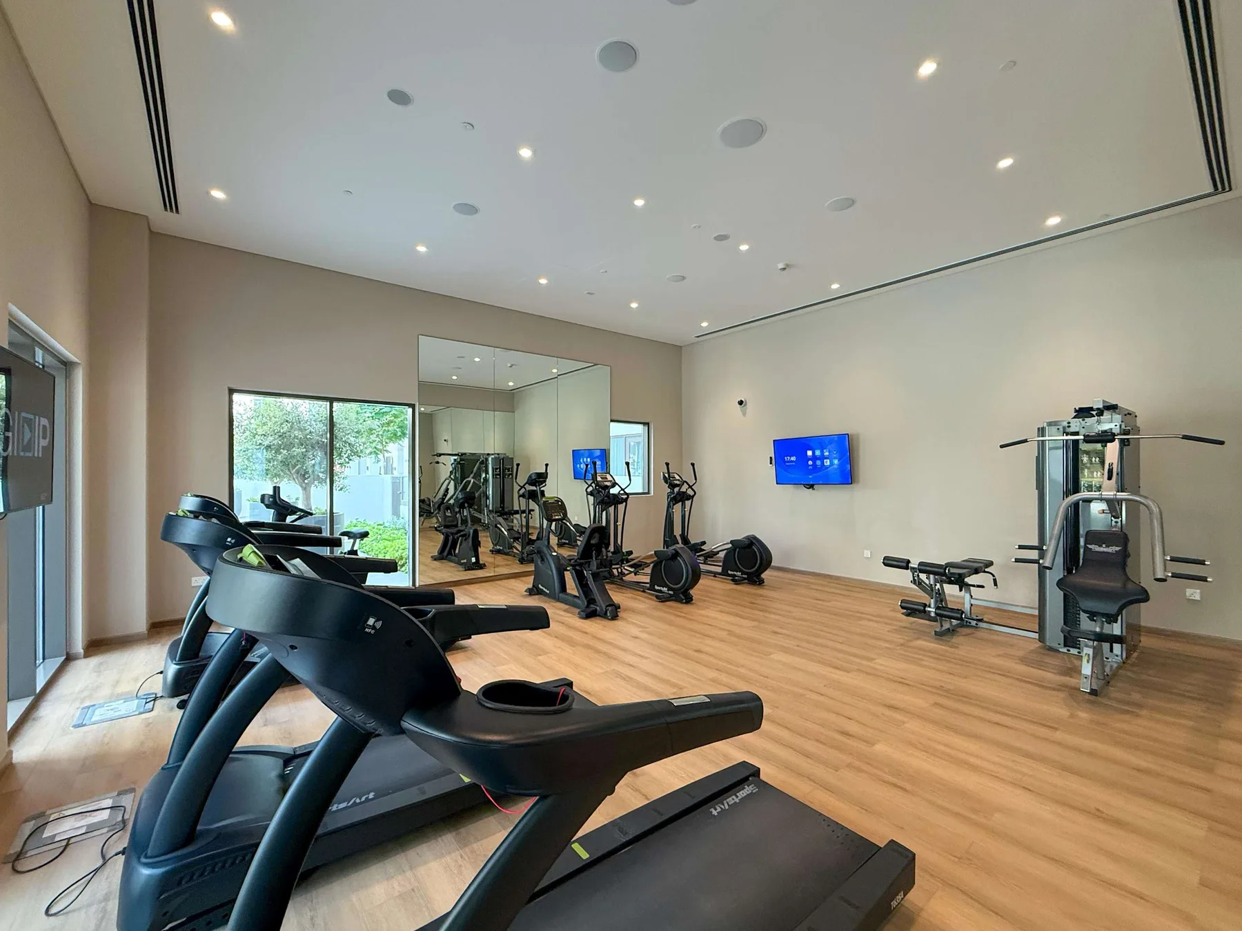 A fitness room with treadmills, exercise bikes, and strength-training equipment.