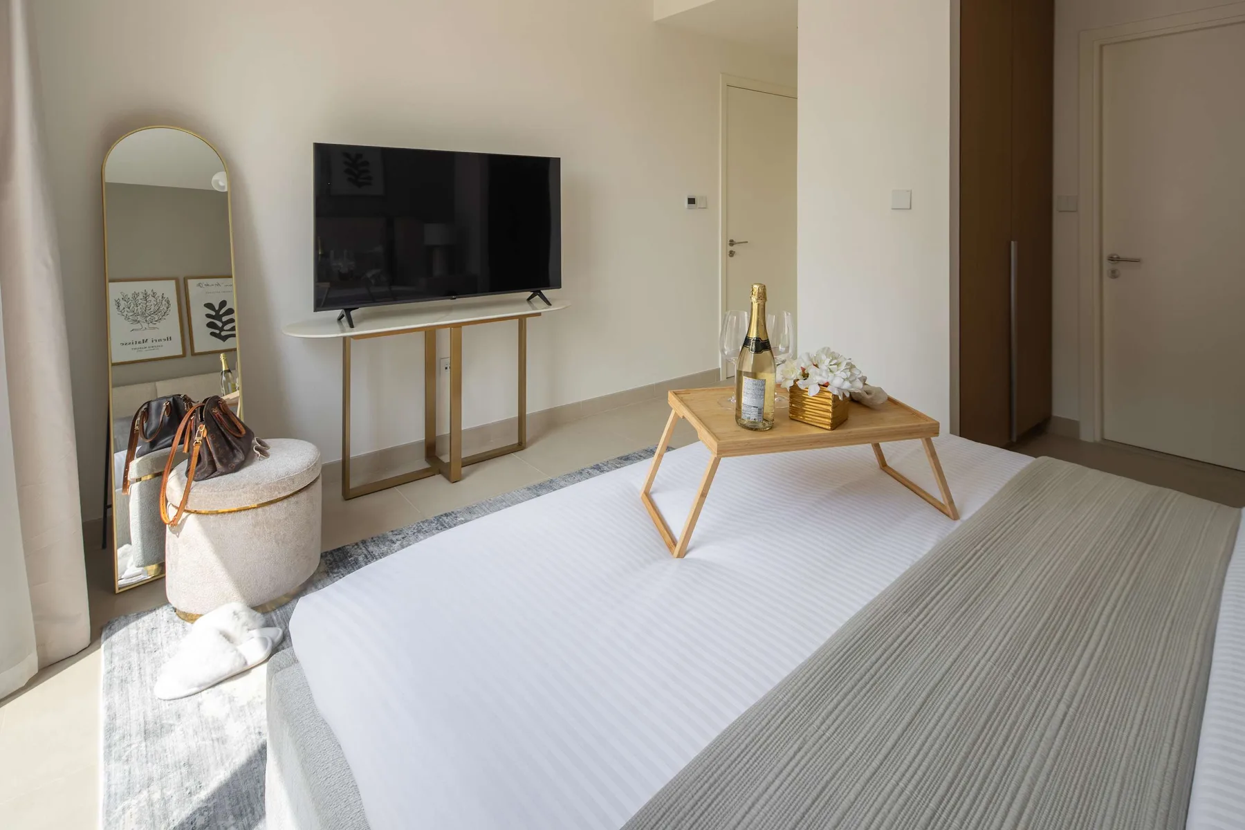 A bright living room with a wall-mounted television and a low coffee table.