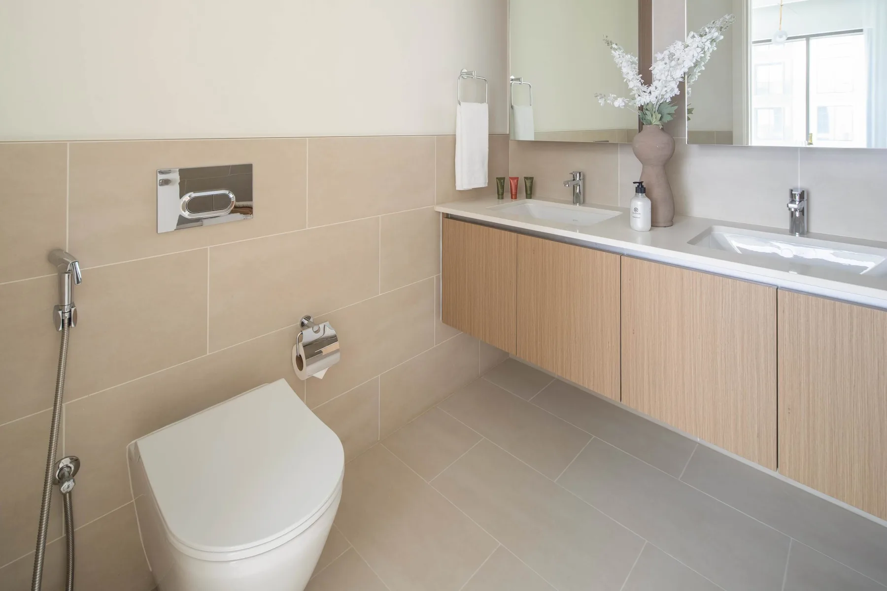 A modern bathroom with a toilet, vanity, and sink.