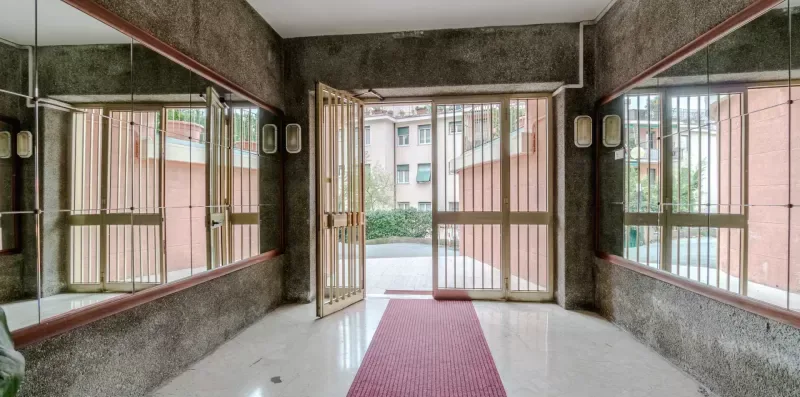 A mirrored entryway with barred glass doors opening to the street.