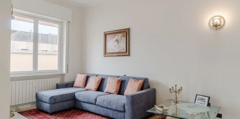 A living room with a gray sectional and a large window.