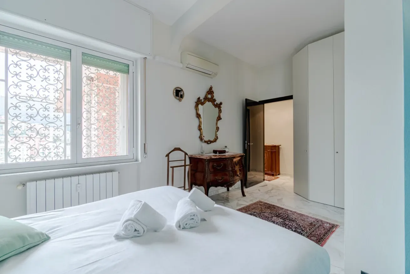 A bedroom with a bed and an open doorway leading to another room.