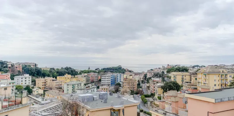 An urban skyline of low-rise buildings beneath a cloudy sky.