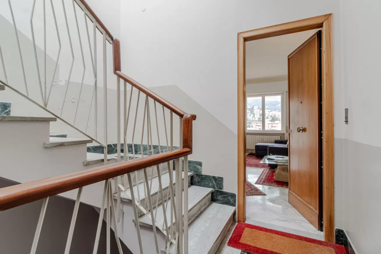 A stairway with metal railings leads to an open doorway.