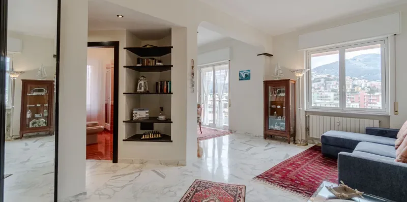 A bright living room with marble-patterned flooring and large windows overlooking the city.