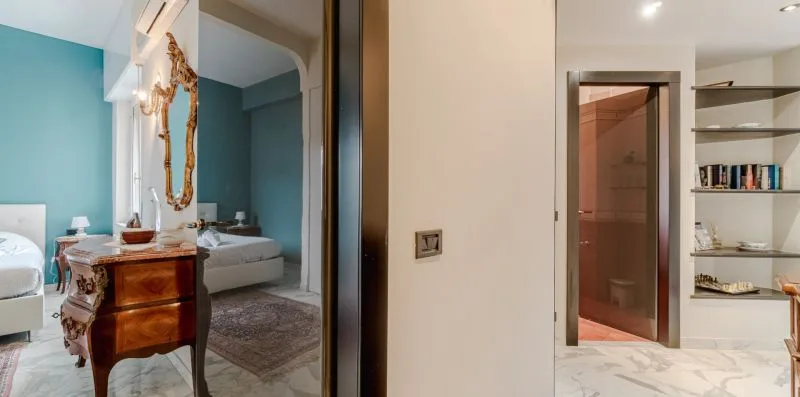 A bedroom with a wooden dresser and a doorway leading to a bathroom.