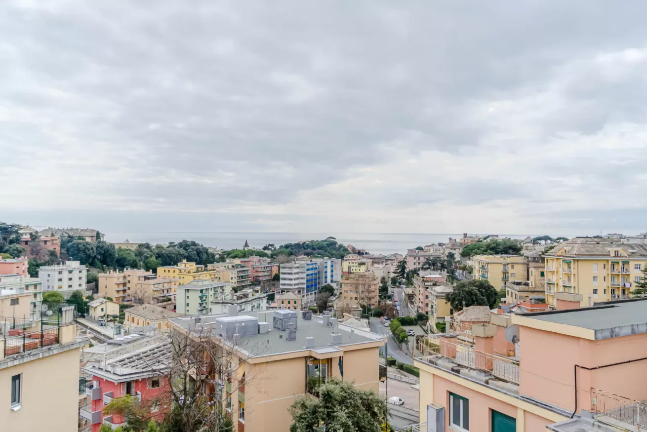 A broad cityscape of low-rise buildings beneath a cloudy sky.
