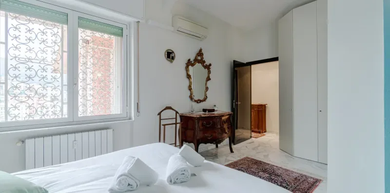 A bedroom with a bed, a window, and an open doorway.