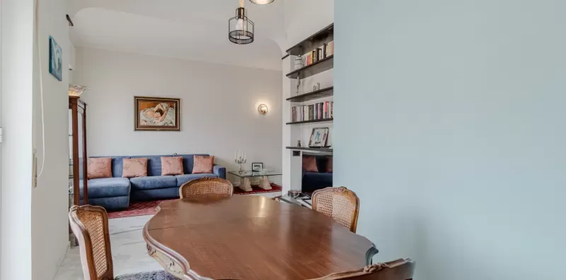 A living and dining area with a blue sofa and wooden dining table.