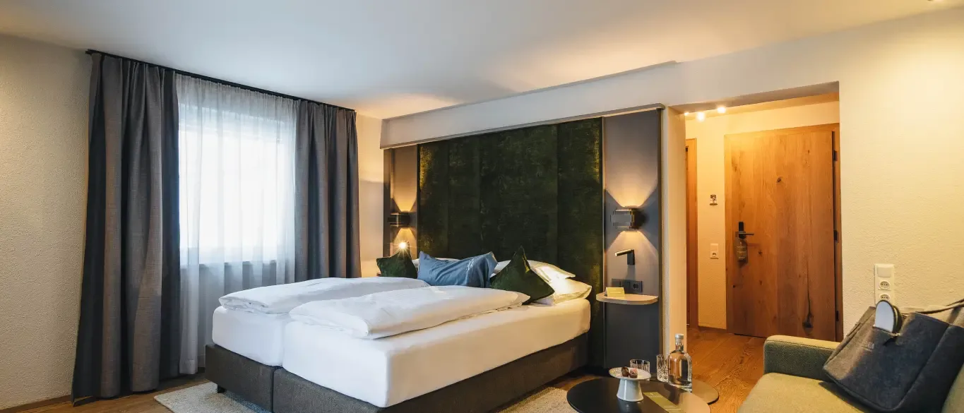 Double room with green headboard and sofa
