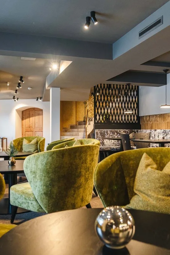 Café seating with green velvet chairs and round tables