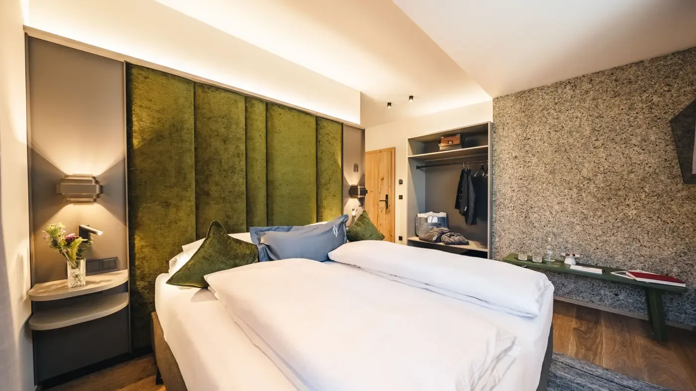 Hotel room with green headboard and modern furnishings
