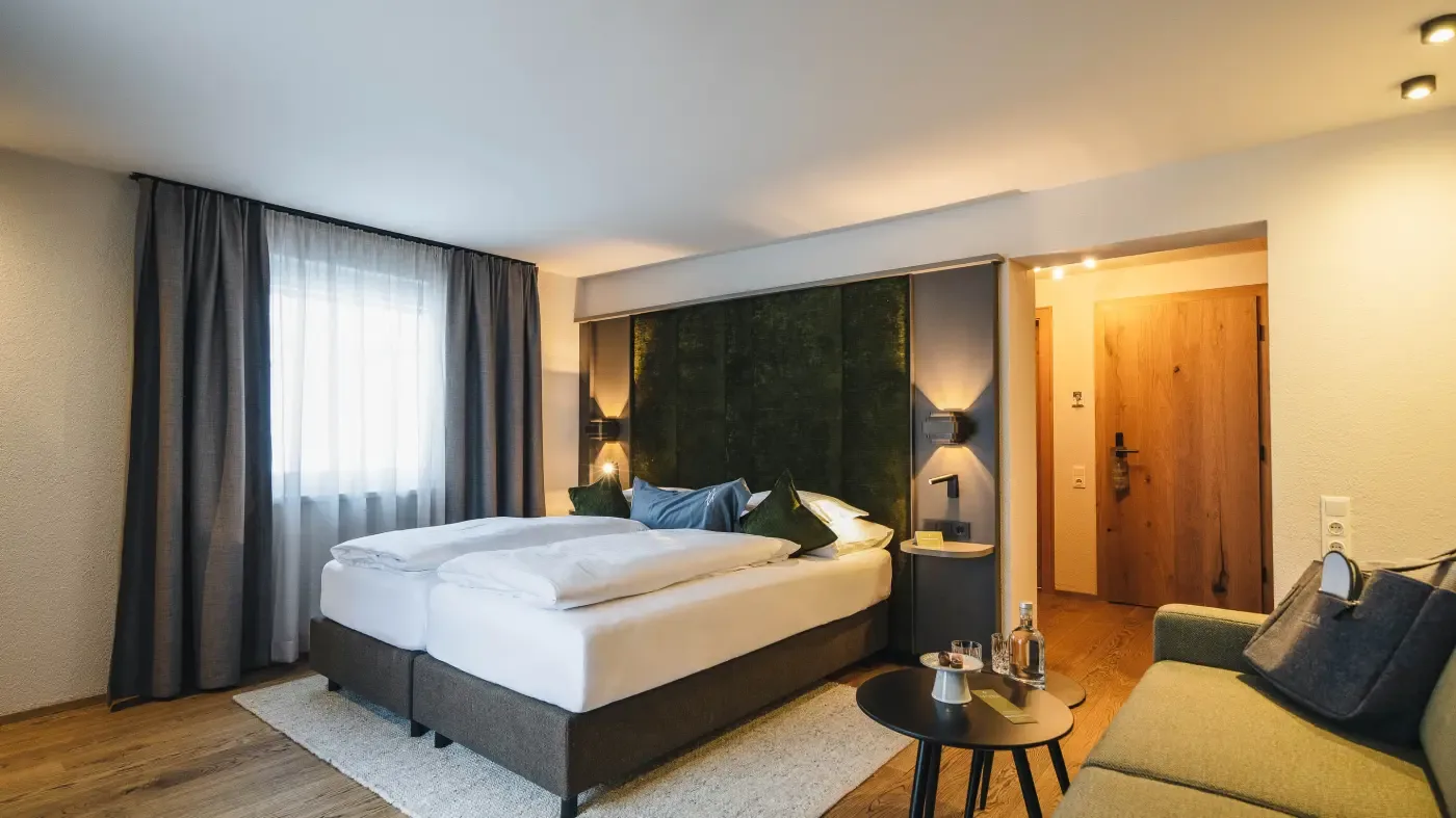 Double room with green headboard and sofa