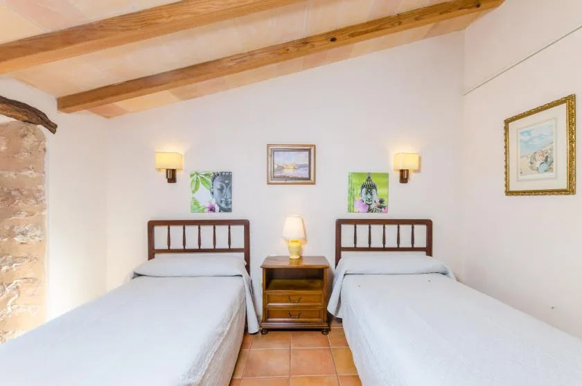 Un dormitorio con dos camas y una mesita de madera entre ellas.