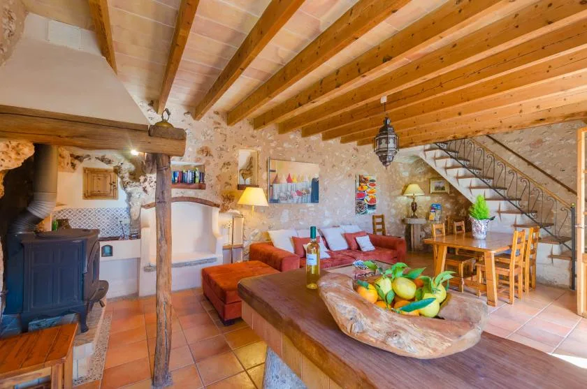 Una sala-comedor rústica de planta abierta con vigas de madera expuestas en el techo.