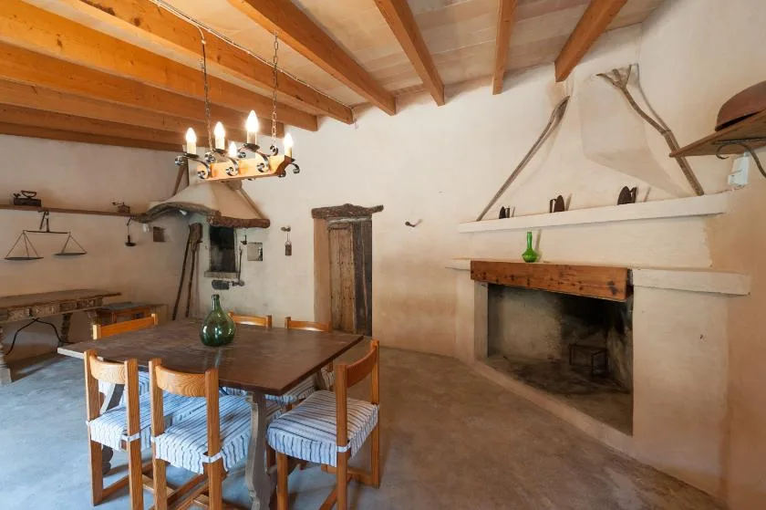 Un comedor rústico con una mesa de madera y una gran chimenea.