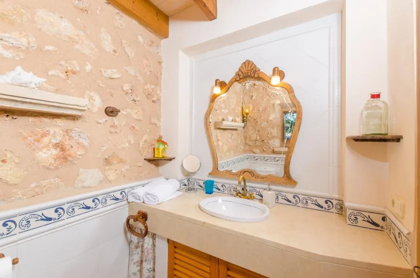 Un lavabo de baño con espejo ornamentado y azulejos decorativos.
