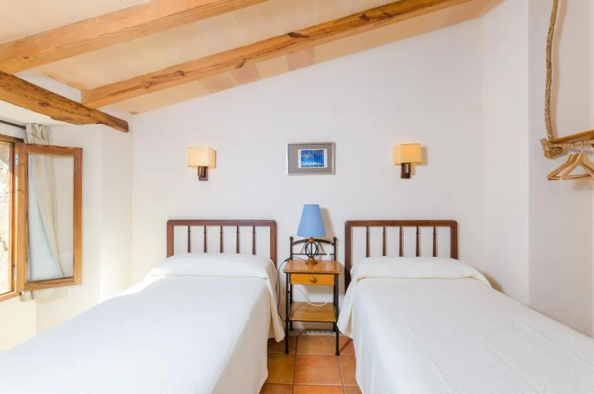 Un dormitorio con dos camas individuales y una mesita entre ellas.