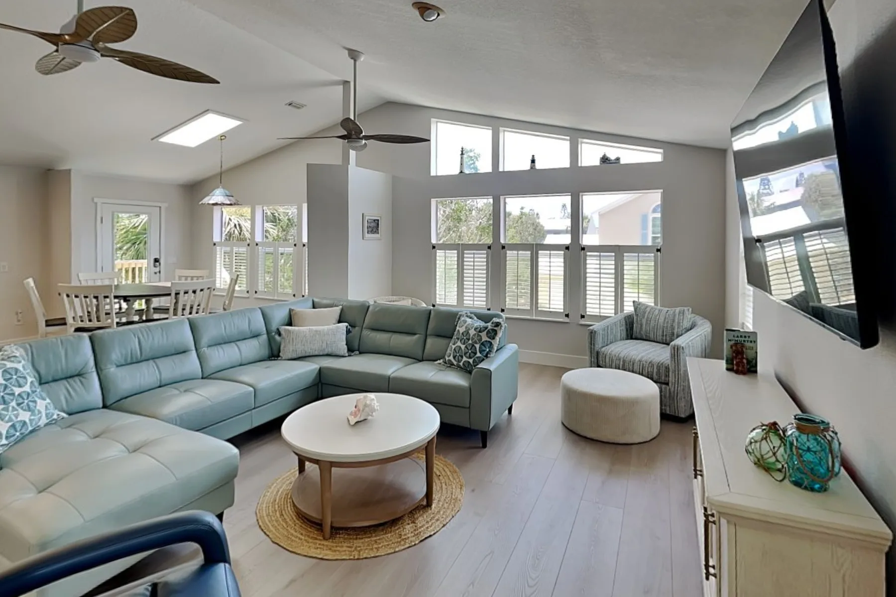 A bright living room with sectional seating and large windows.
