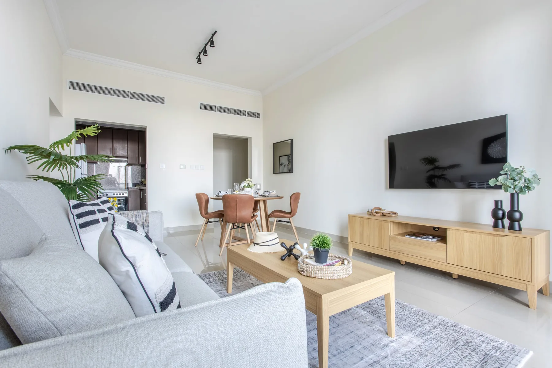 A bright living room with seating, a coffee table, and a television.