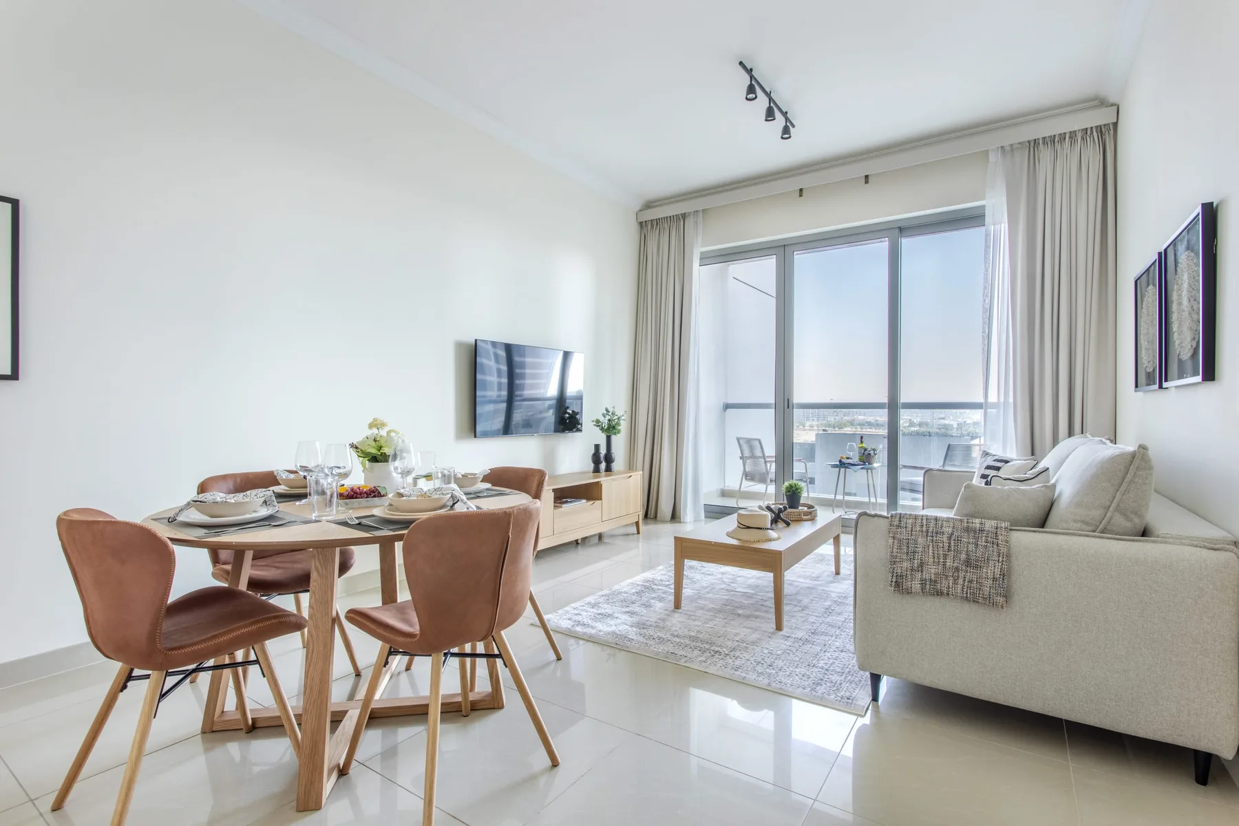 Una luminosa sala de estar y comedor con asientos y grandes ventanas.