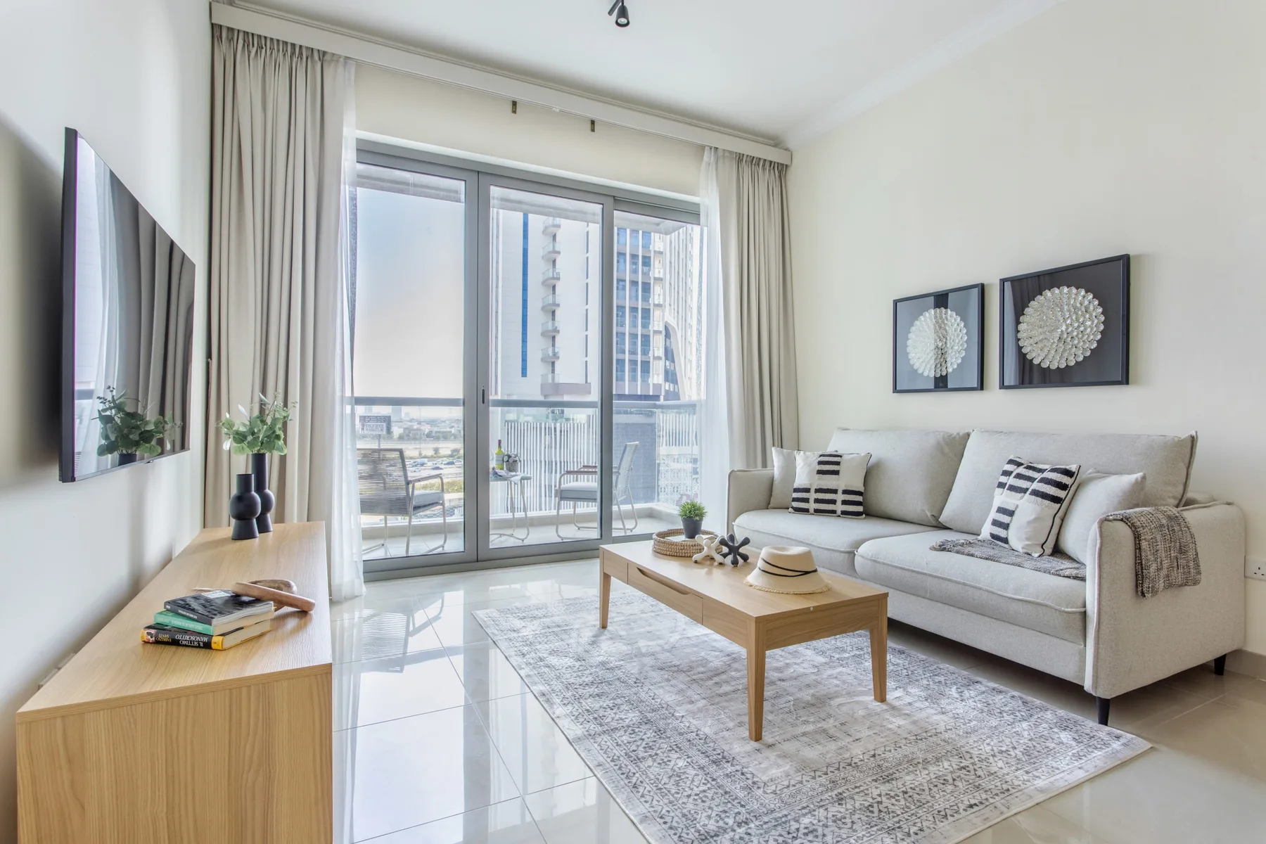 Una sala luminosa con sofá, mesa de centro y puertas de vidrio que dan a un balcón.