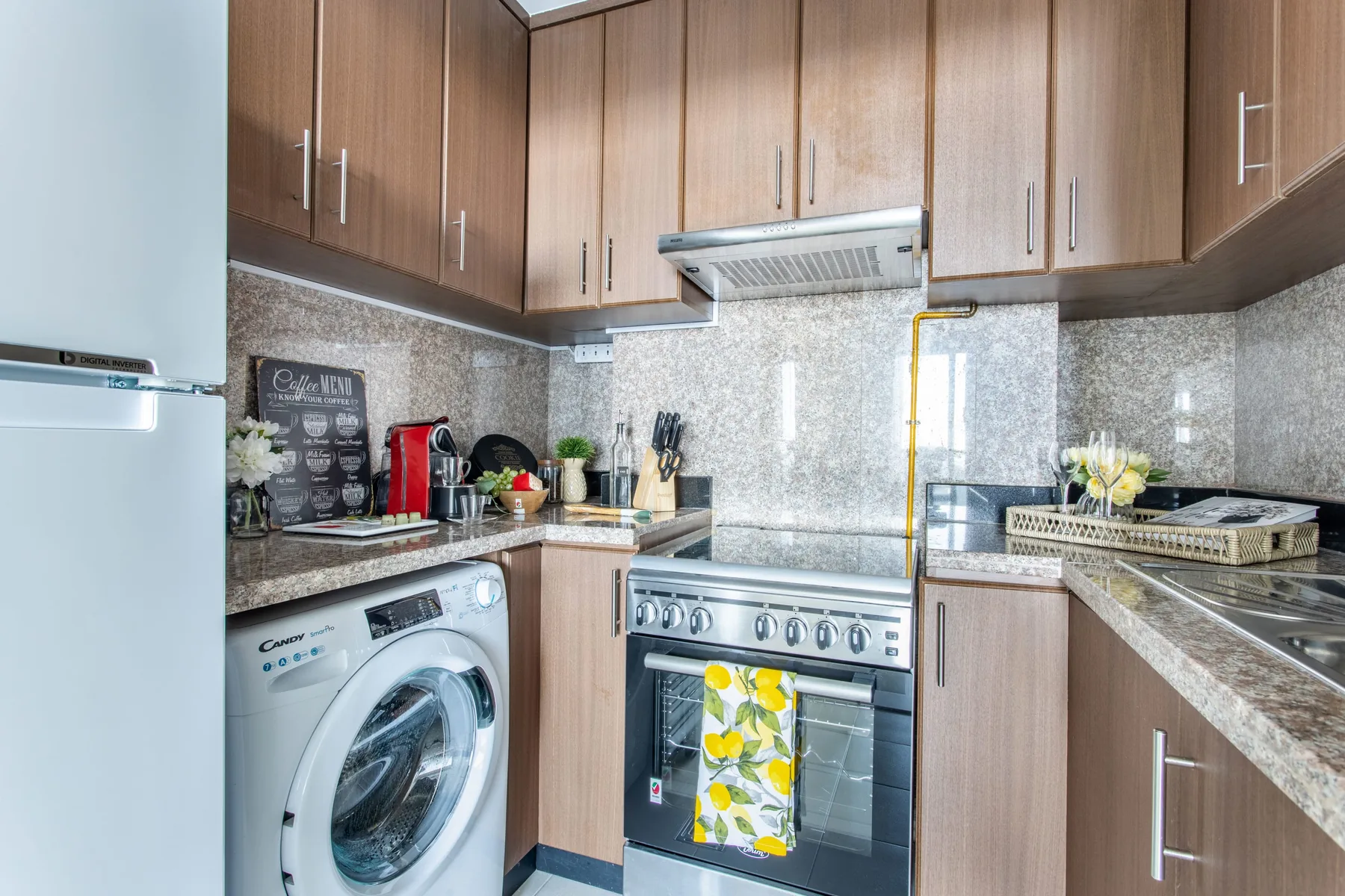 A kitchen with wood cabinets, a stove, and a washing machine.