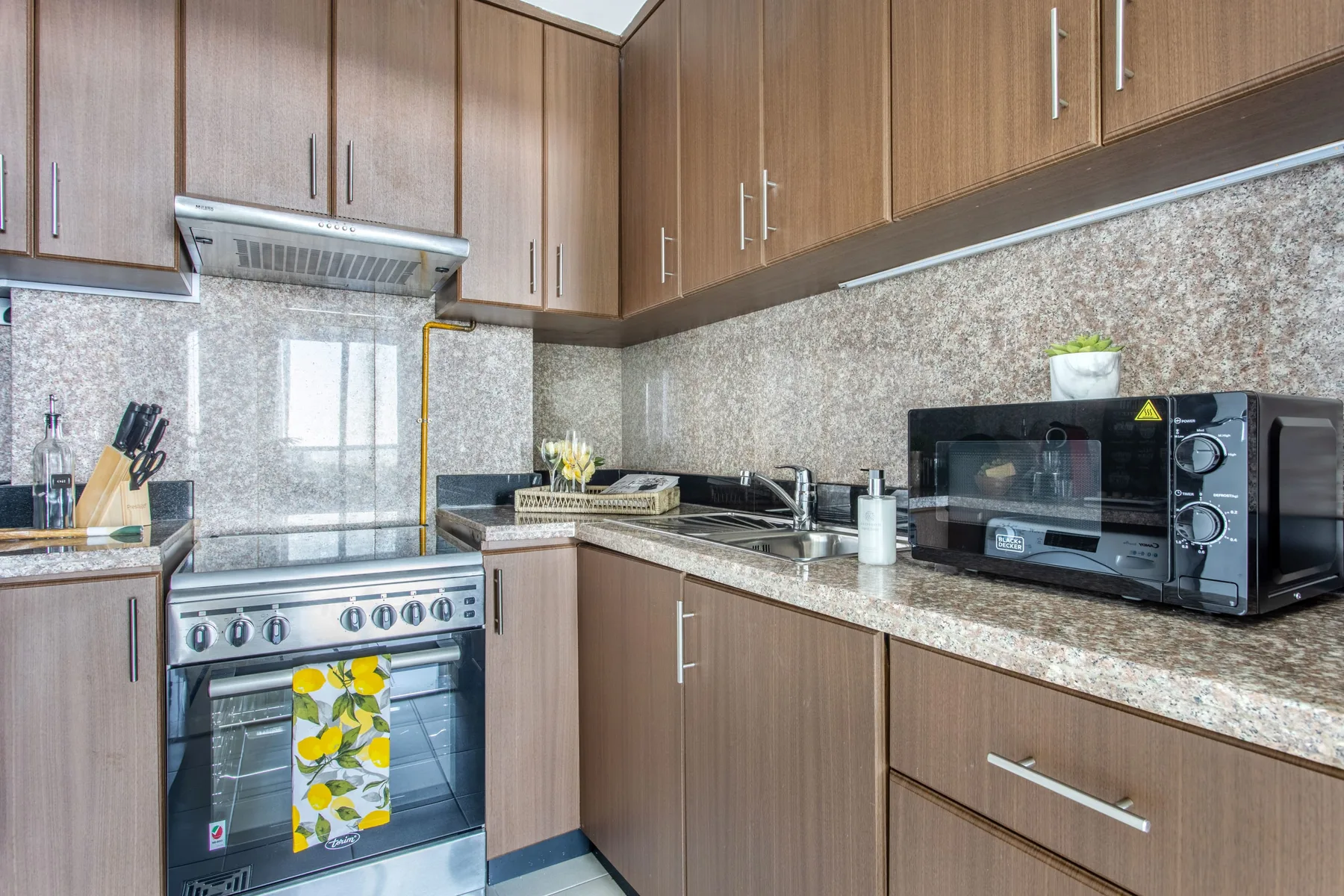 A kitchen with wood cabinets, a countertop, and cooking appliances.