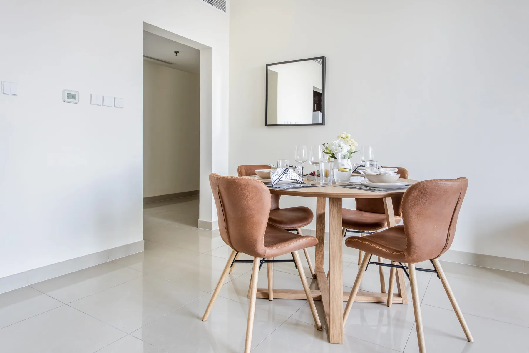 Un comedor con la mesa puesta y asientos tapizados.