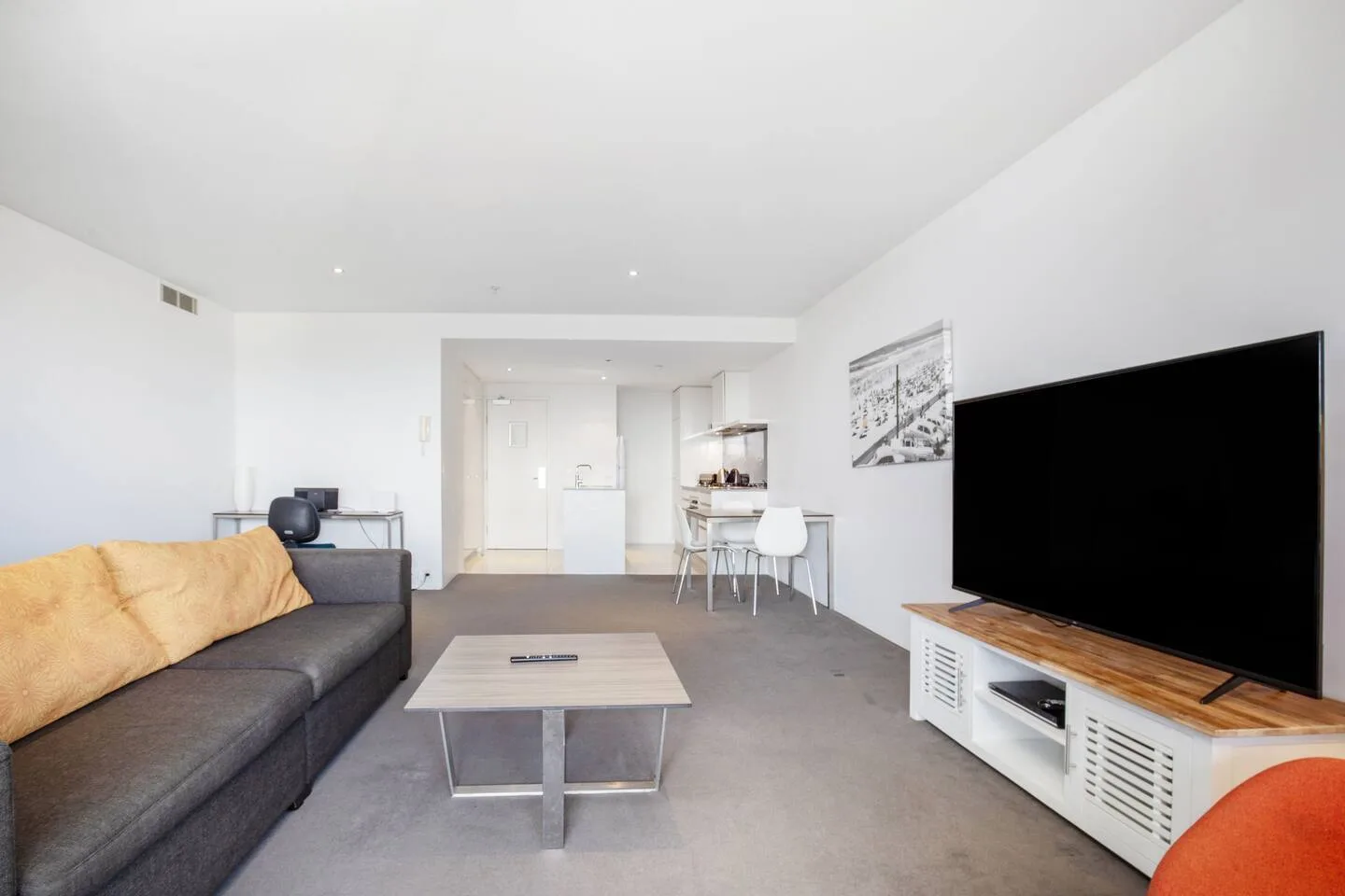 A living room with a coffee table, seating, and a television.