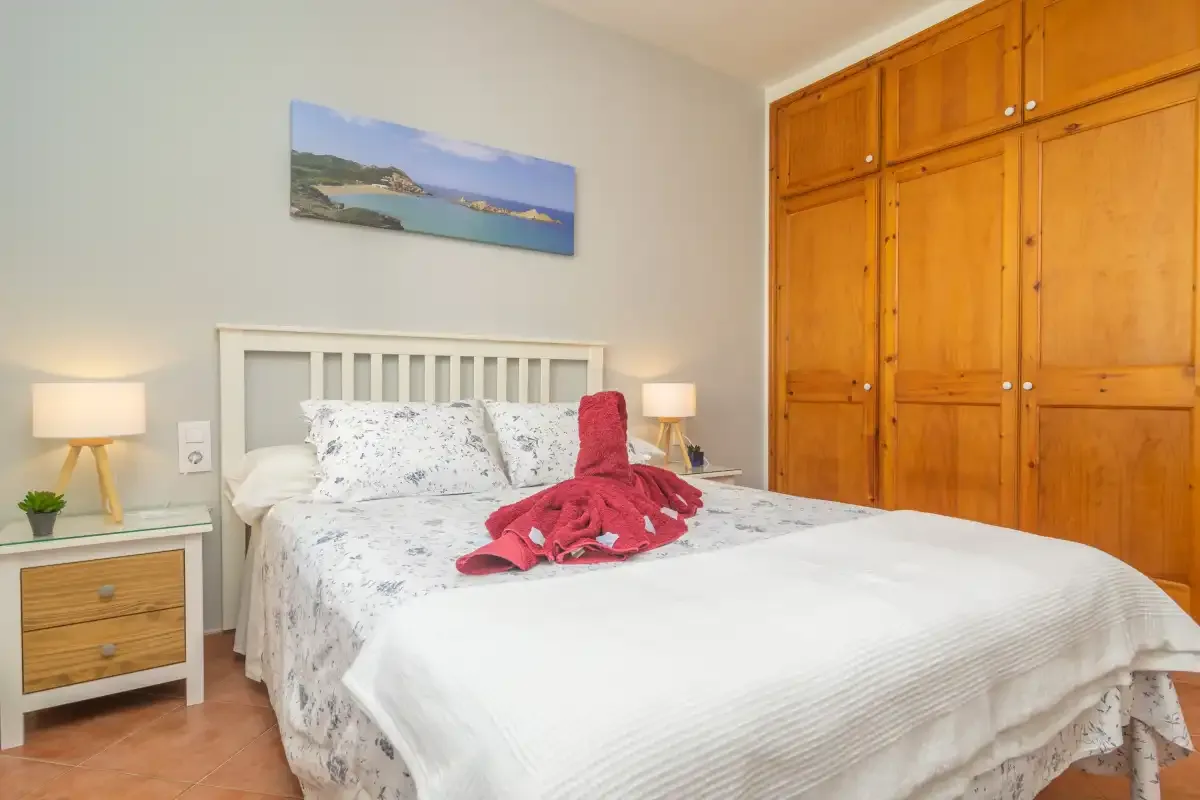 Un dormitorio con una cama doble y un gran armario de madera.
