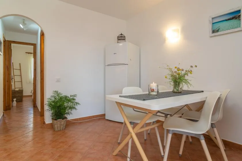 Un comedor con una mesa y sillas junto a un refrigerador.