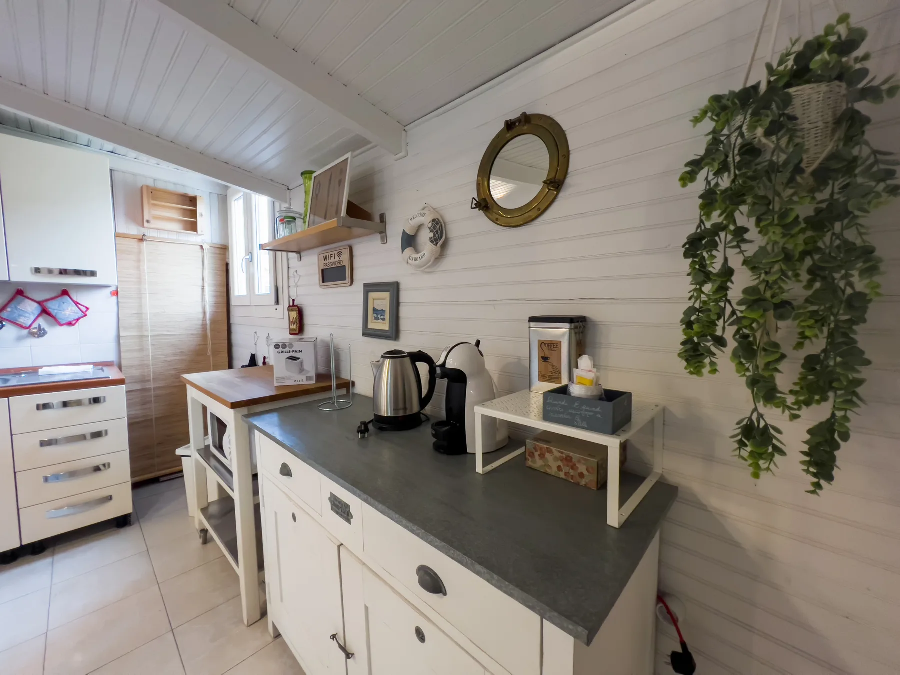 Una cocina luminosa con gabinetes blancos y una encimera oscura.