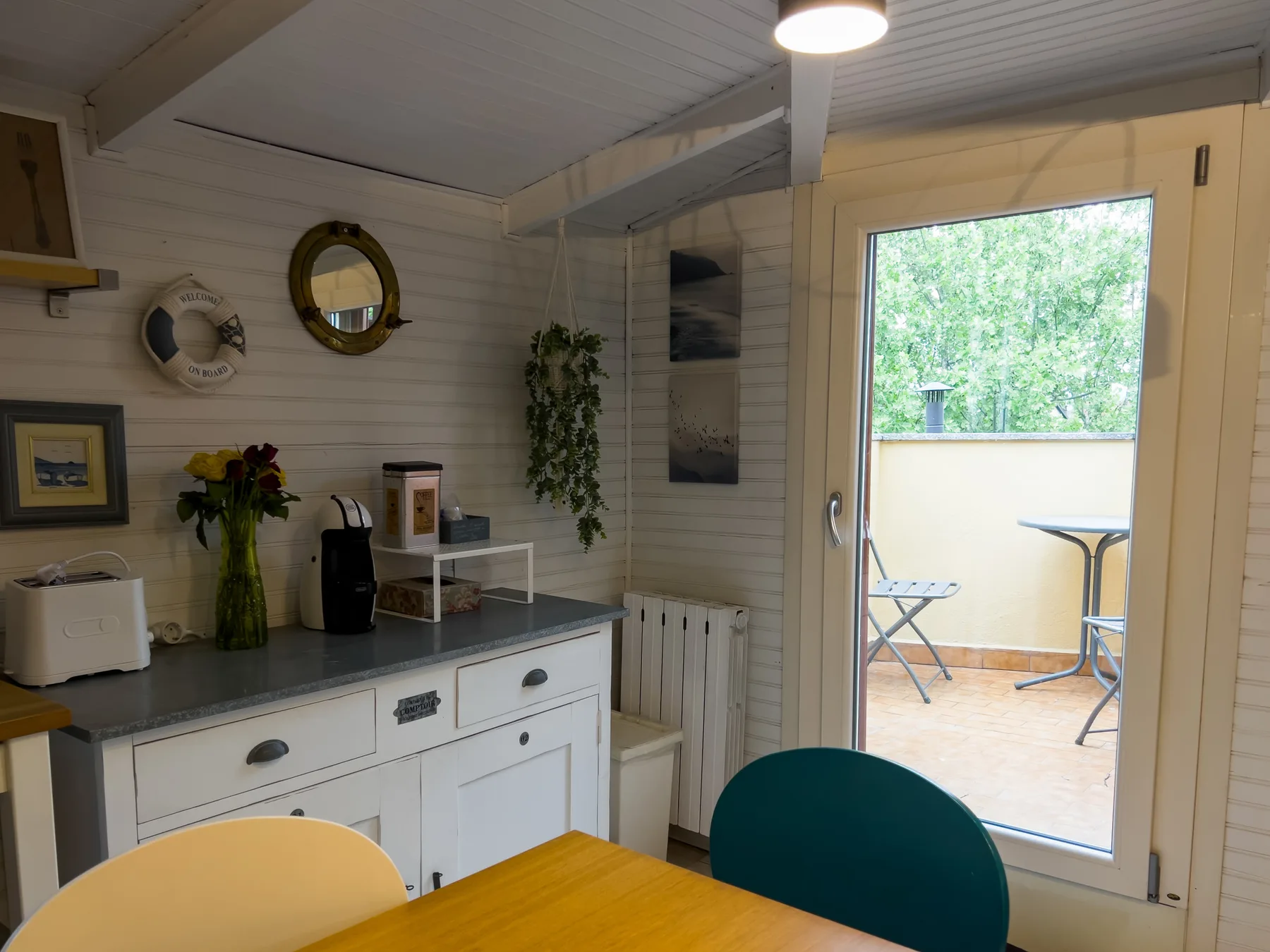 Comedor con una mesa de madera junto a una puerta de vidrio que da a un pequeño patio.