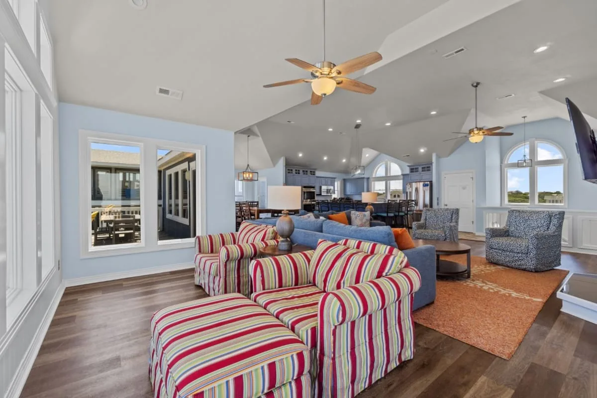 An open living room with colorful striped seating and a dining area.