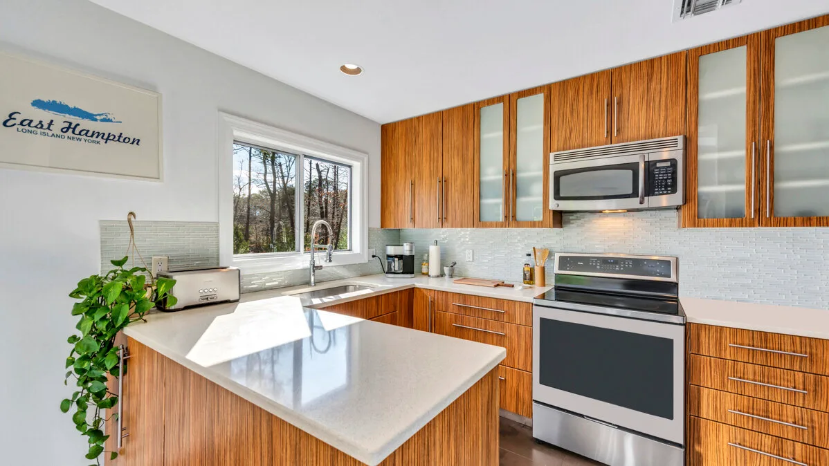 A bright kitchen with wood cabinets, a central island, and stainless steel appliances.