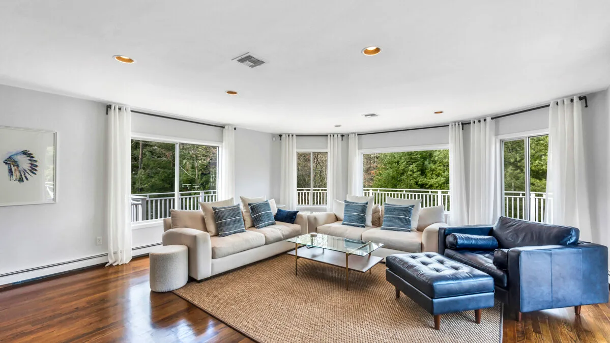 A bright living room with seating around a coffee table and large windows.