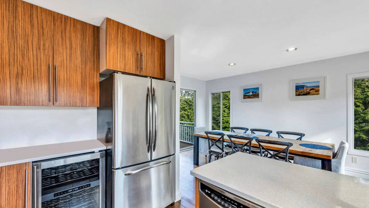 A bright kitchen and dining area with wood cabinetry and a long dining table.